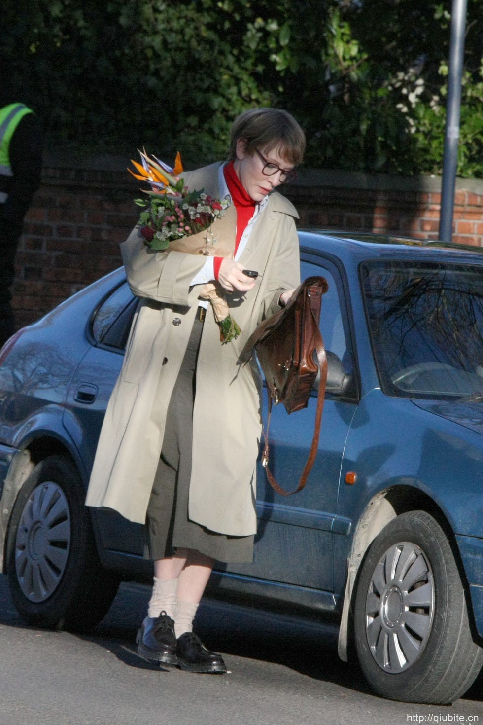 a person in a garment holding flowers 奶油色薄风衣演绎春日的柔美与优雅