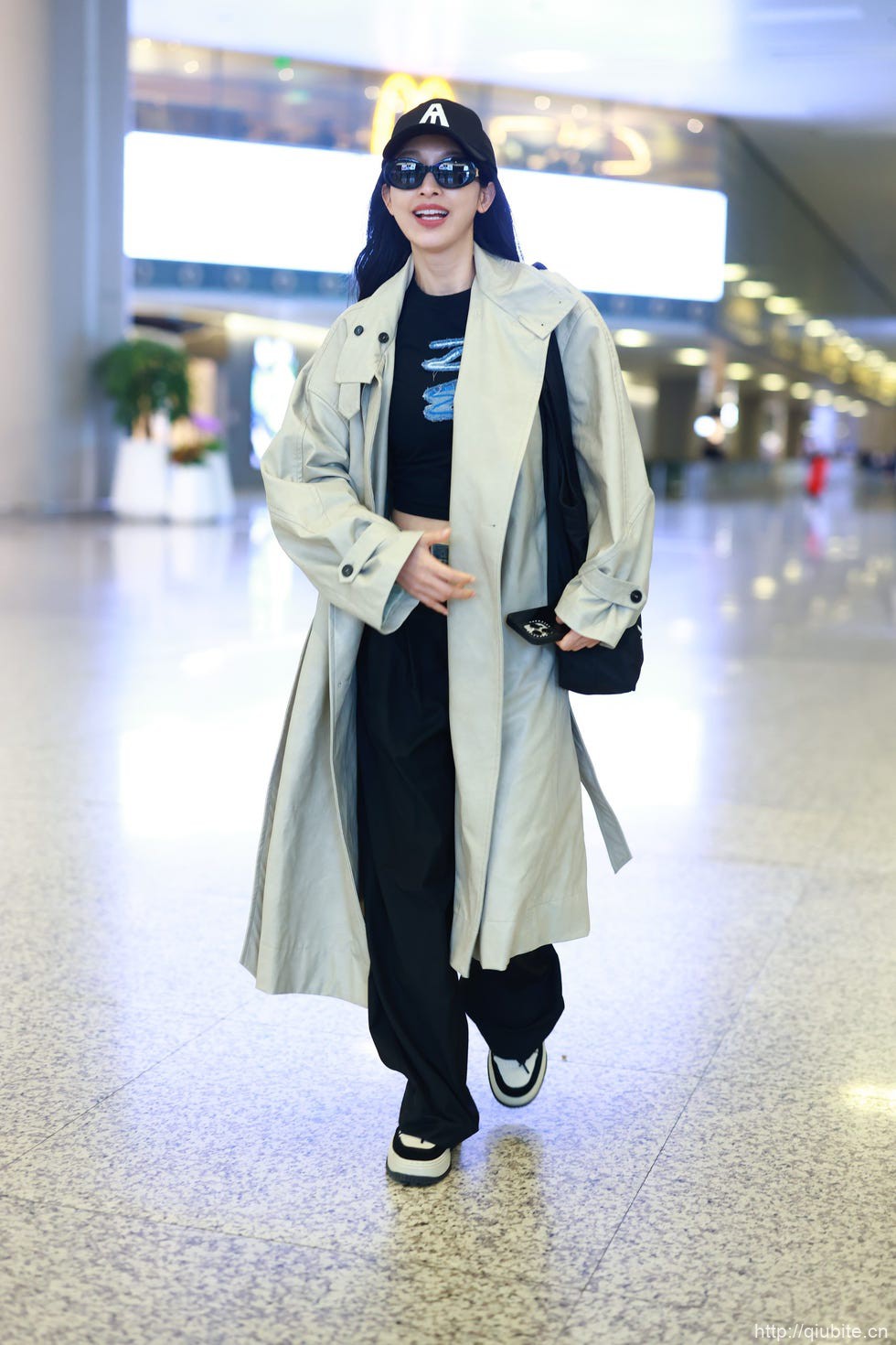 a person wearing a white coat and sunglasses 奶油色的薄风衣演绎春日的轻松与雅致