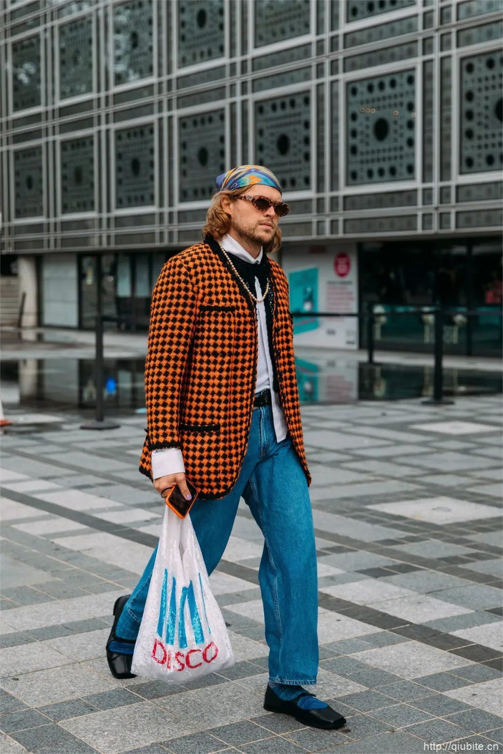a man in a suit and hat holding a bag 为什么2024年了,芭蕾平底鞋还在流行?