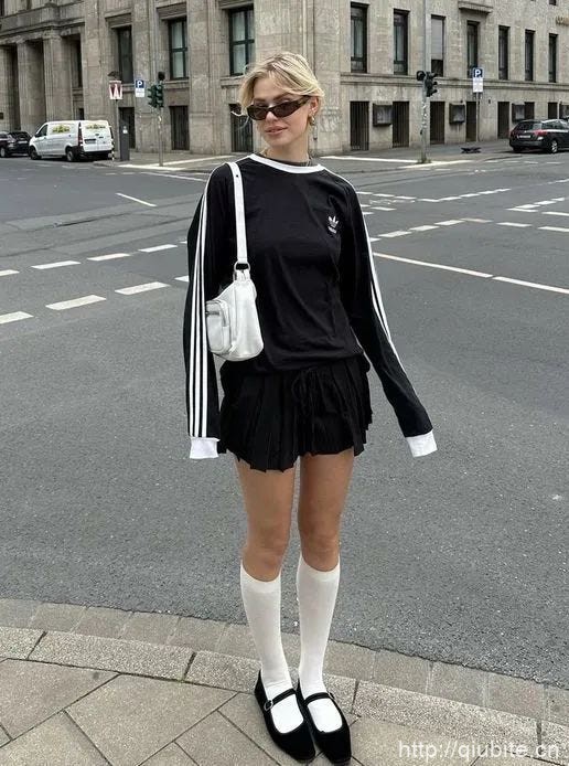 a woman in a black dress and sunglasses standing on a sidewalk 为什么2024年了,芭蕾平底鞋还在流行?