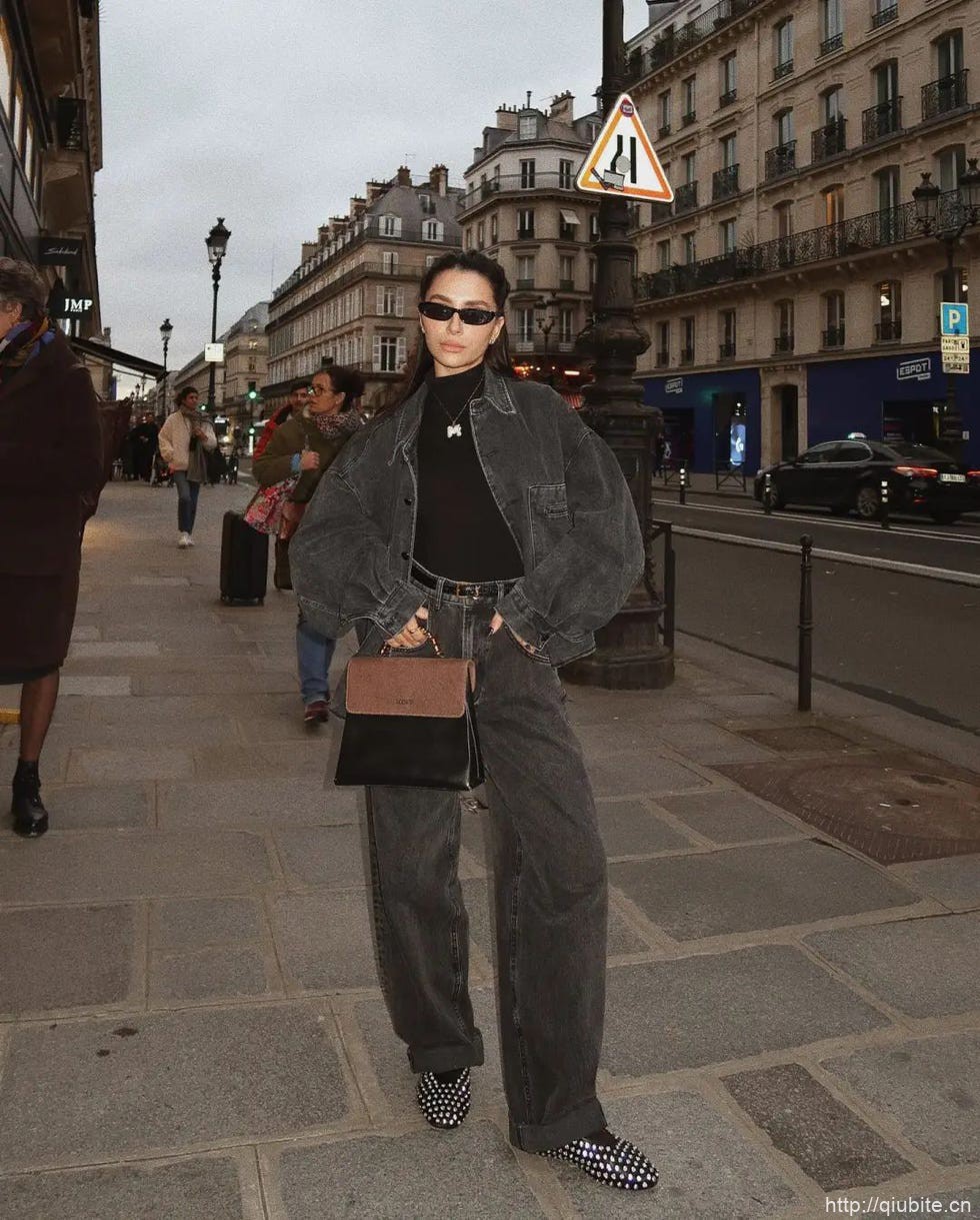 a person in sunglasses and a leather jacket walking down a sidewalk 为什么2024年了,芭蕾平底鞋还在流行?