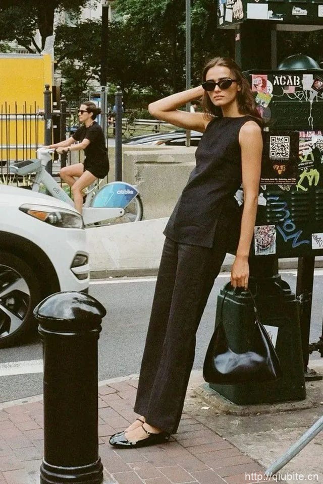 a person in a black dress walks down the sidewalk 为什么2024年了,芭蕾平底鞋还在流行?