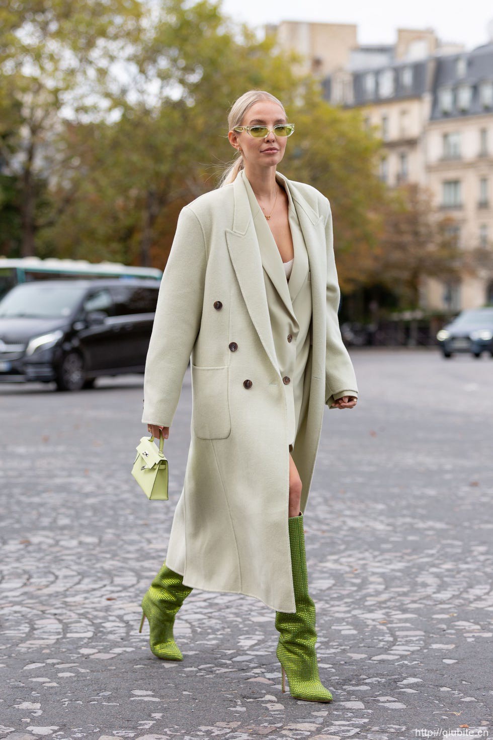 a man in a white coat and green boots walking on a street 西装大衣叠穿外套,双重温度与风度