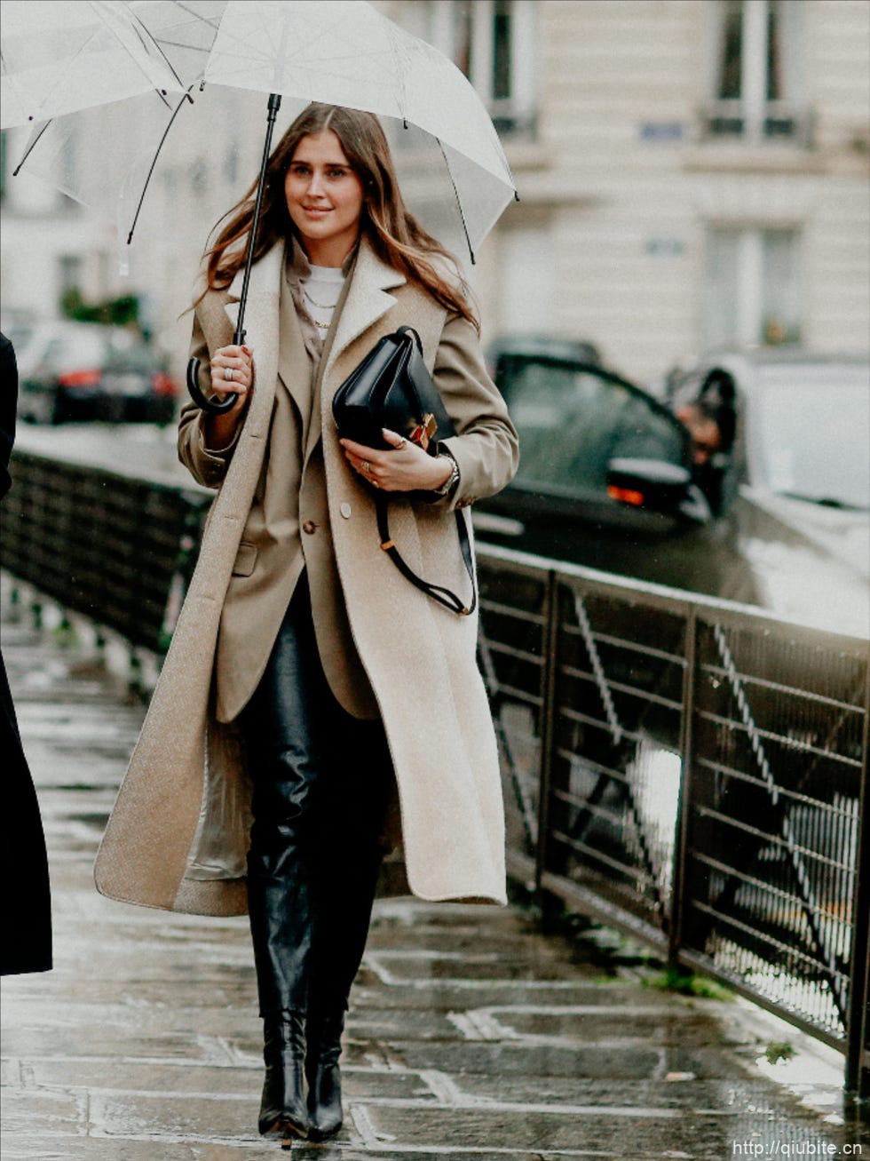 a person holding an umbrella 西装大衣叠穿外套,双重温度与风度