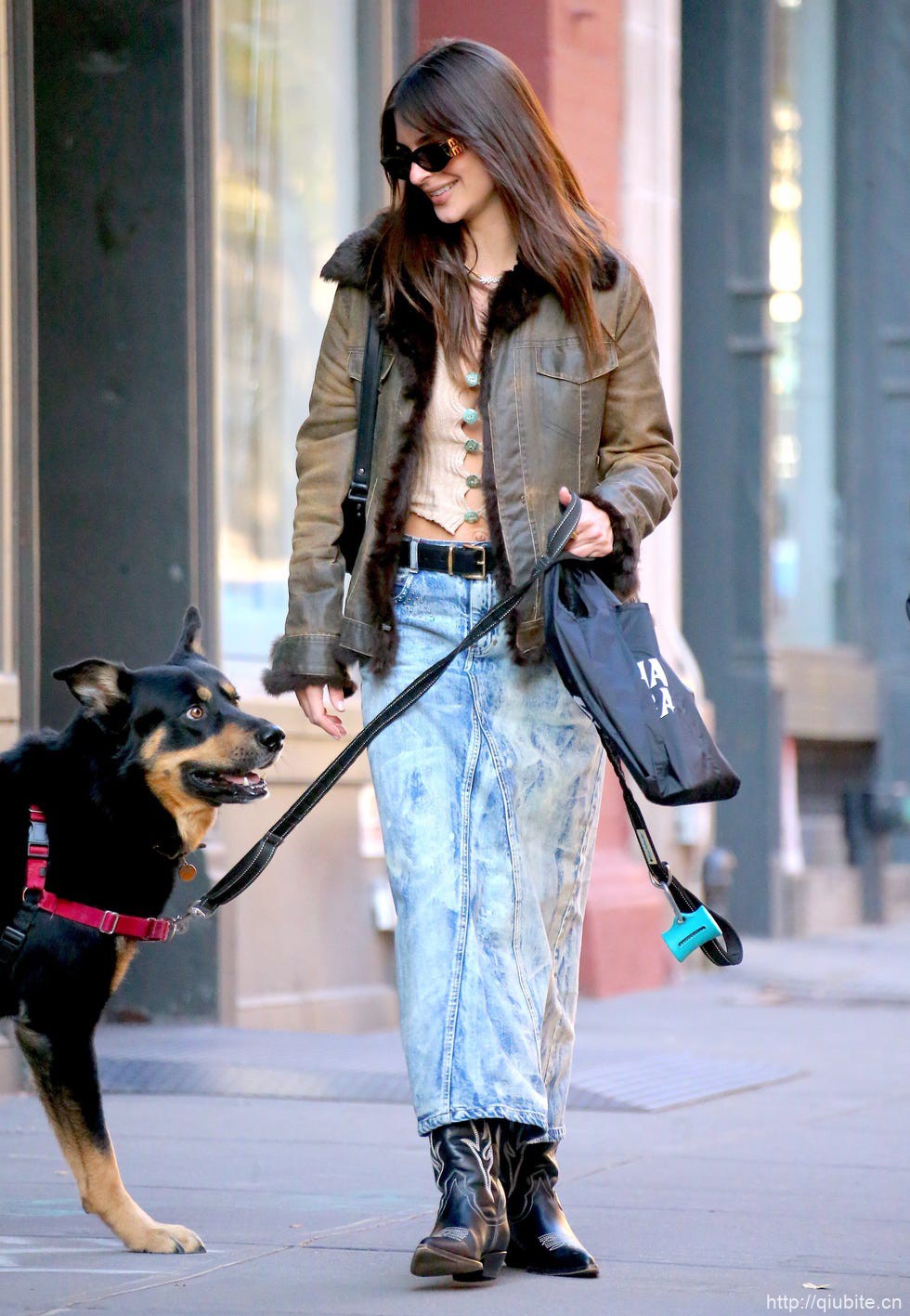 a woman walking a dog 冬日暖阳下的时髦选择:毛领夹克