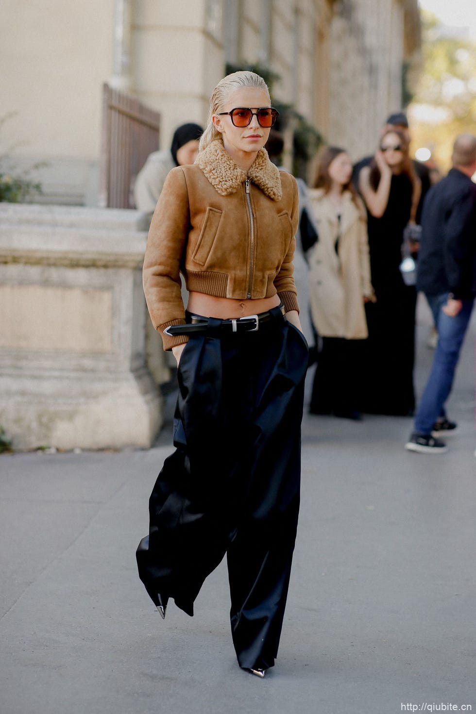 a person wearing sunglasses and a brown jacket 冬日暖阳下的时髦选择:毛领夹克